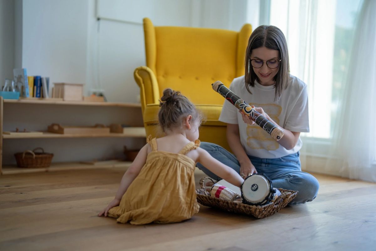 Woman and child playing with toys on the floor